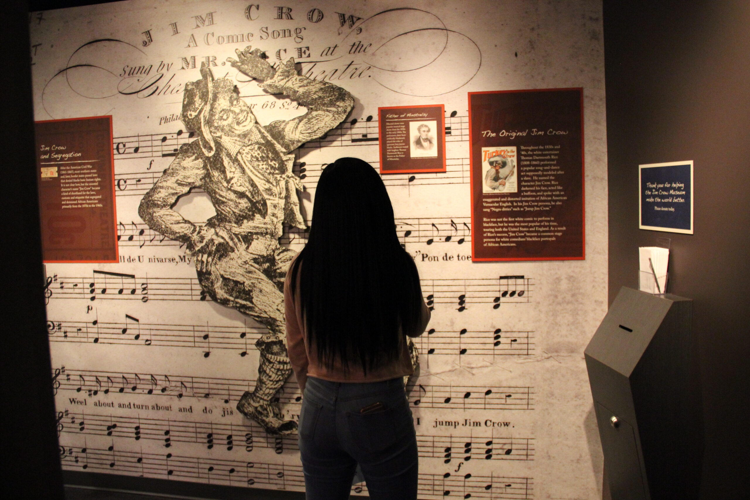 Visitor reading a wall display at the Jim Crow Museum.