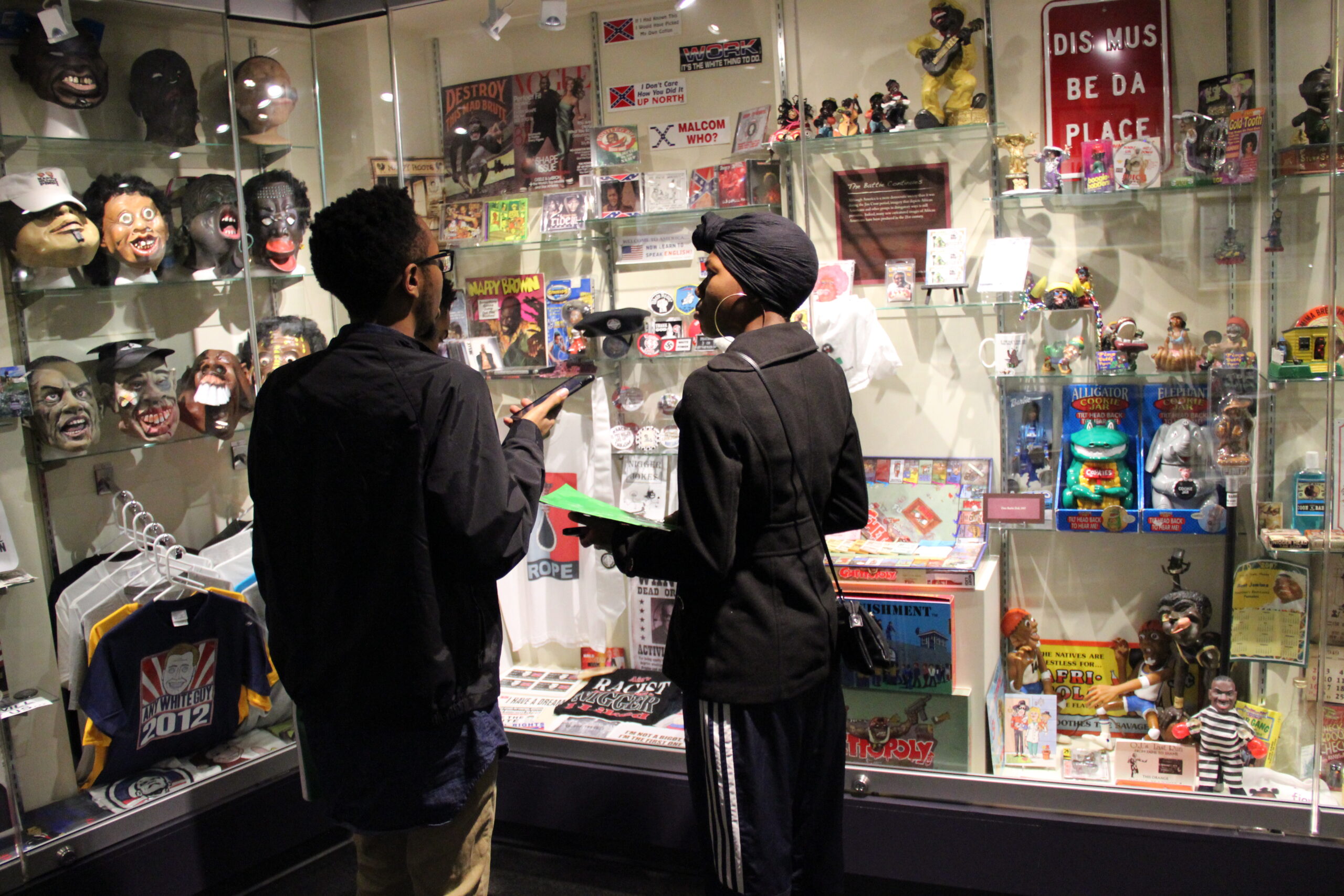 Two visitors standing in front of a display case at the Jim Crow Museum.